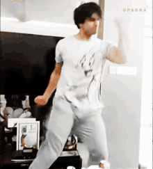 a man in a white shirt is dancing in front of a sign that says 1st on it