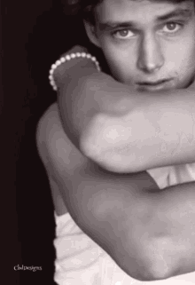 a black and white photo of a man with a bracelet on his wrist taken by owldesigns