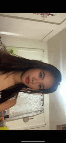 a woman taking a selfie in a bathroom with a shower curtain behind her