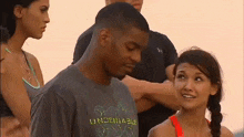 a group of people are standing around a man wearing a t-shirt that says unbelievable .