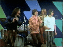 a group of men are standing on a stage with microphones