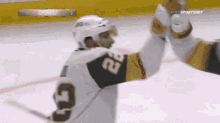 a hockey player with the number 22 on his jersey giving another player a high five