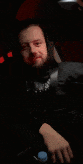 a man wearing a black shirt that says ' arizona ' on it is sitting in a car