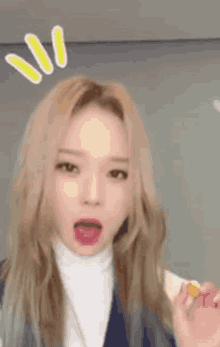 a close up of a woman with blonde hair making a funny face with her tongue out .