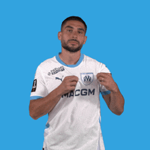 a man wearing a white shirt with the word macgm on the front