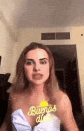 a woman wearing a white top has a sticker on her chest that says buenas dios