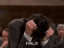 a man in a suit and tie is holding his hair in his hands and says fml .