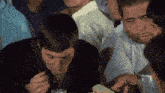 a group of people are sitting around a table eating food