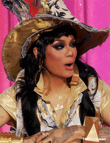 a woman wearing a cowboy hat and earrings is holding a trophy