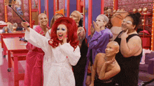 a group of drag queens are posing for a picture in a dressing room