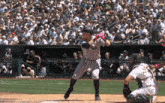 a new york yankees player swings at a pitch during a baseball game