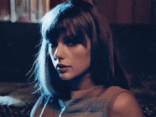 a woman with long hair is sitting on a couch and looking at the camera