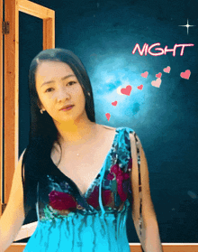 a woman in a blue dress is standing in front of a night sign