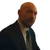 a bald man wearing a suit and tie is looking at the camera