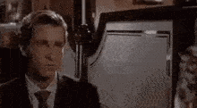 a man in a suit and tie is making a face in a bar .