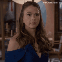 a woman in a blue dress smiles and says " g ' night "
