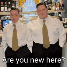 two women standing next to each other with the words " are you new here " on the bottom right