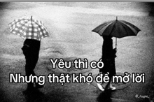 a black and white photo of two people holding umbrellas