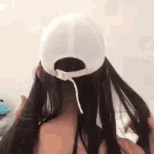 a woman with long hair is wearing a baseball cap .