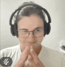 a woman wearing headphones and glasses is smiling and making a face .