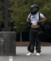 a man wearing a helmet and a crop top that says groovy