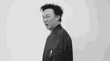 a black and white photo of a man wearing a black jacket .