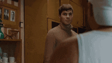 a man in a turtleneck sweater looks at another man
