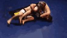 two men are wrestling in a ring with the word rc on the mat