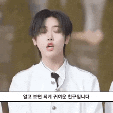 a man in a white suit and tie is making a funny face .