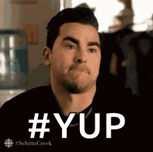 a man in a black shirt says #yup on a screen