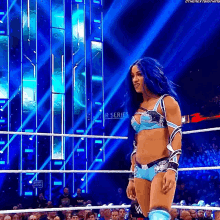 a woman with blue hair is in a wrestling ring .