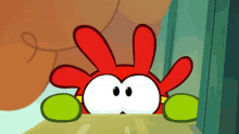 a cartoon character with red ears and green arms is peeking out from behind a table