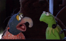 kermit the frog is wearing headphones while talking to a blue bird