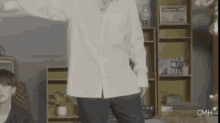 a man in a white shirt is dancing in front of a sign that says old man rick