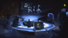 a group of people are gathered around a table with a computer screen that says ' t ' on it