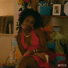 a woman in a pink dress sits in front of a shelf with a picture of a girl on it