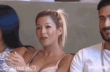 a man and a woman are sitting next to each other on a couch . the woman is wearing a bra .