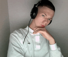 a young man wearing headphones and a white shirt with a lacoste logo