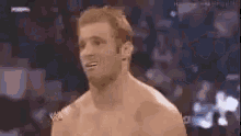 a shirtless man is standing in front of a crowd .