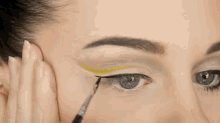 A Winged Eyeliner Look With A Pop Of Color GIF - Makeup Cateye Yellow GIFs