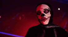 a person wearing a skull mask and a black shirt that says ' n ' on the sleeve
