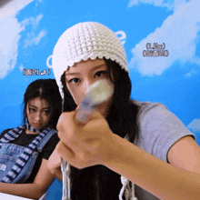 a girl wearing a white hat holds a spoon in her mouth