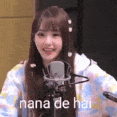 a girl is standing in front of a microphone with the words nana de hai written on it .
