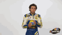 a man wearing a napa auto parts uniform is praying with his hands together .