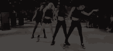 a group of young women are dancing in a dark room .