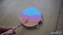 a person is painting a picture of a sunset with the words made in animatica on the bottom