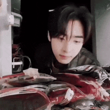 a young man is looking into a refrigerator filled with lots of food .