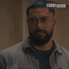 a man with a beard is wearing a grey shirt with the word countdown on it