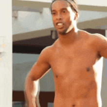 a shirtless man with a headband on his head is standing in front of a building