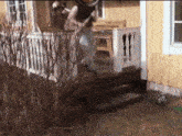 a person is standing on the porch of a yellow house